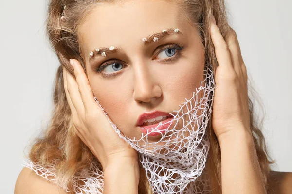 Young woman with creative eyebrows on grey background — Stock Photo, Image