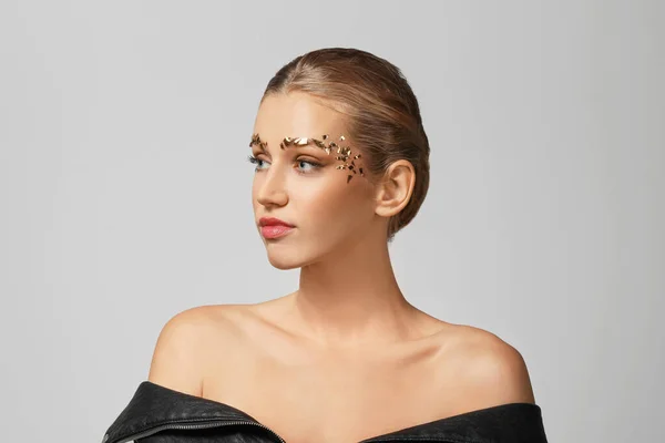 Mujer joven con cejas creativas sobre fondo gris — Foto de Stock