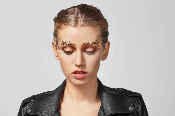 Mujer joven con cejas creativas sobre fondo gris — Foto de Stock