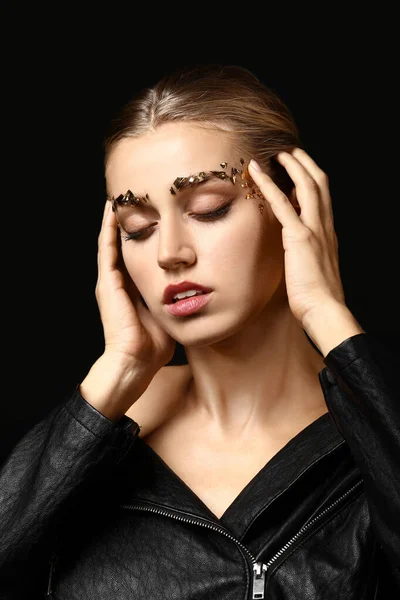 Young woman with creative eyebrows on dark background — Stock Photo, Image