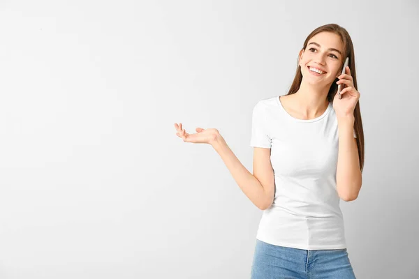 아름다운 십 대 소녀가 흰색 배경으로 전화로 이야기하는 모습 — 스톡 사진