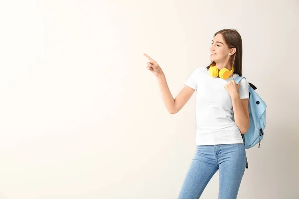 Beautiful female student pointing at something on white background — Stock Photo, Image