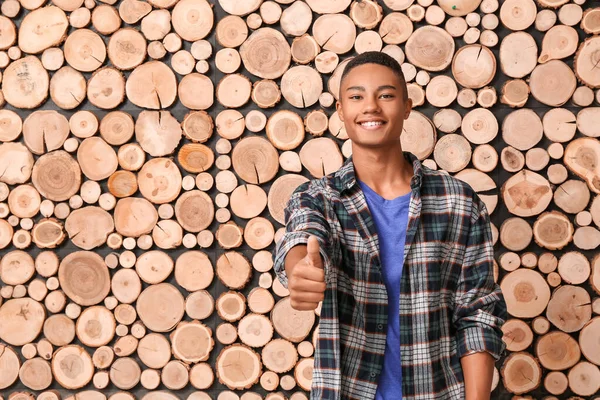 Menino adolescente afro-americano mostrando polegar para cima em fundo de madeira — Fotografia de Stock