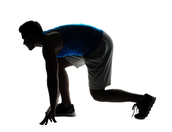 Silhouette of sporty young man in crouch start position on white background — Stock Photo, Image