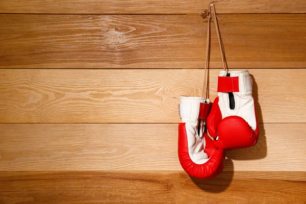 Pair of boxing gloves hanging on wooden wall — Stock Photo, Image