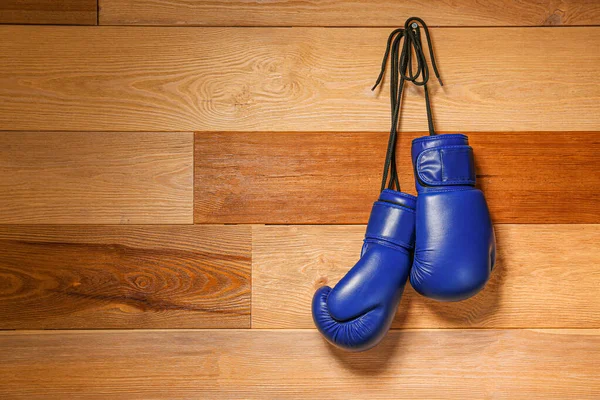 Pareja de guantes de boxeo colgados en pared de madera — Foto de Stock