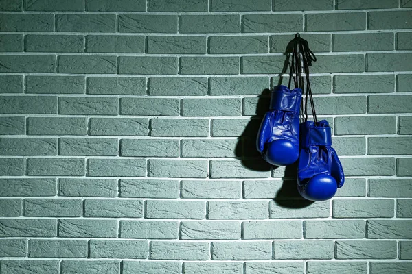 Par de guantes de boxeo colgados en la pared de ladrillo — Foto de Stock