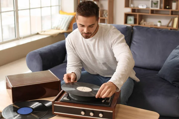 Joven escuchando música a través de un tocadiscos en casa —  Fotos de Stock