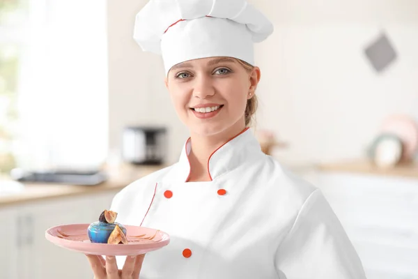 Confeiteiro feminino com sobremesa saborosa na cozinha — Fotografia de Stock
