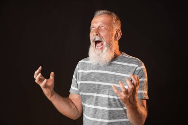 Karanlık arka planda öfkeli olgun adam