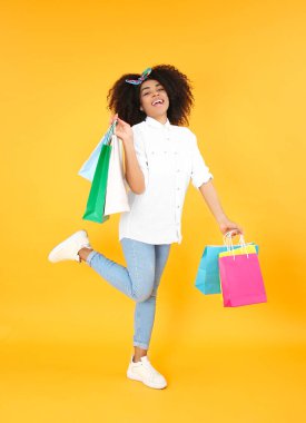 Arkaplanda alışveriş torbaları olan güzel Afro-Amerikalı kadın.