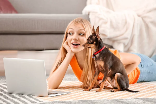 Mulher bonita com cão terrier brinquedo bonito usando laptop em casa — Fotografia de Stock