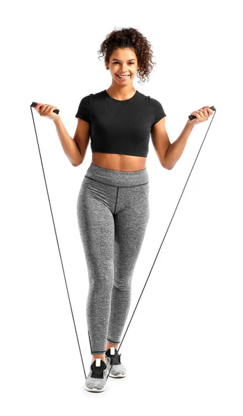 Sporty African-American woman with jumping rope on white background — Stock Photo, Image