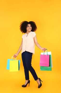 Arkaplanda alışveriş torbaları olan güzel Afro-Amerikalı kadın.