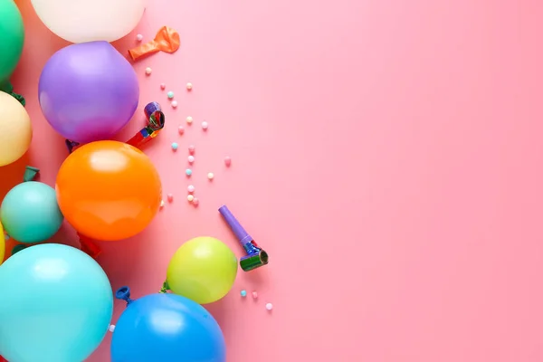 Globos y silbatos de fiesta sobre fondo de color —  Fotos de Stock
