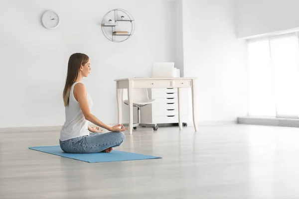 Young woman practicing yoga at home — Stock Photo, Image