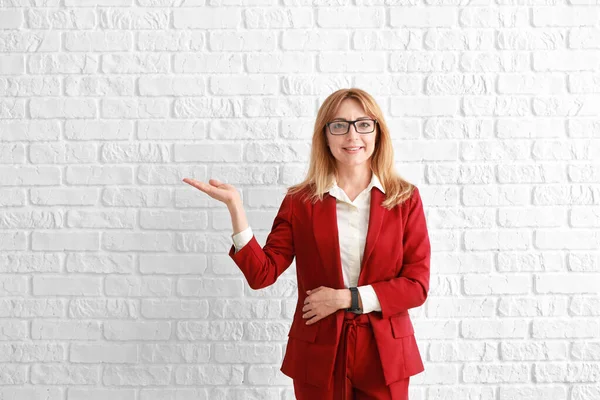 Portrait of stylish mature businesswoman showing something on white background — Stock Photo, Image