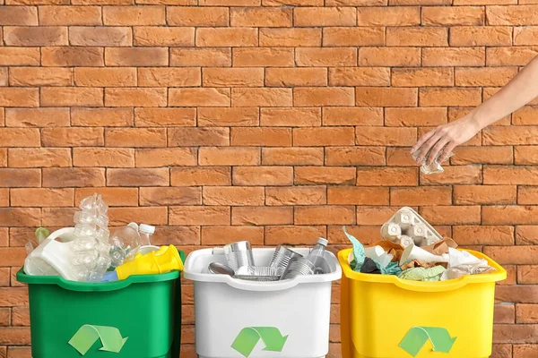 Uma mulher a atirar lixo para o contentor. Conceito de reciclagem — Fotografia de Stock