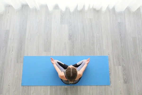 Giovane donna che pratica yoga a casa — Foto Stock