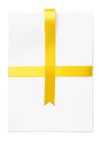 Blank sheet of paper with golden ribbon on white background — Stock Photo, Image