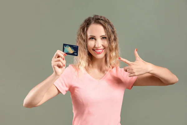 Jeune femme avec carte de crédit sur fond de couleur — Photo