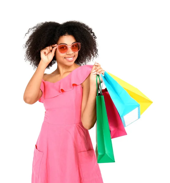 Beautiful African-American woman with shopping bags on white background — Stock Photo, Image