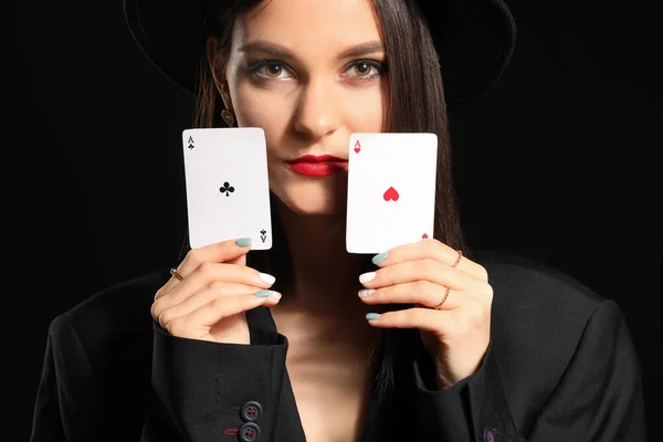 Mulher bonita com cartas de jogar no fundo escuro — Fotografia de Stock