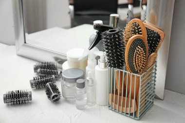 Profesyonel kuaför aletleri ve kozmetik ürünleri salondaki masada.