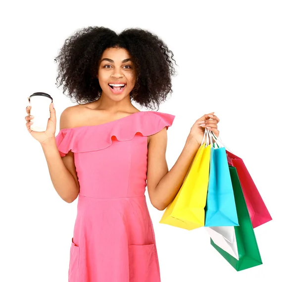 Beautiful African-American woman with shopping bags and coffee on white background — Stock Photo, Image