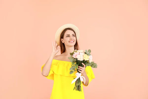 Piękna młoda kobieta z bukietem goździków kwiaty na tle koloru — Zdjęcie stockowe