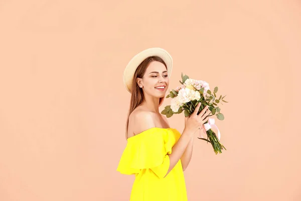 Beautiful young woman with bouquet of carnation flowers on color background — Stock Photo, Image