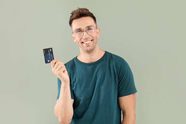 Jovem com cartão de crédito sobre fundo de cor — Fotografia de Stock