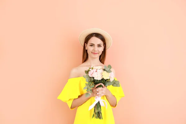 Hermosa mujer joven con ramo de flores de clavel sobre fondo de color —  Fotos de Stock