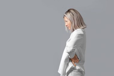 Gri arka planda yaratıcı makyajı olan güzel bir kadın.