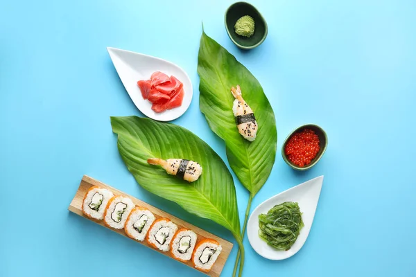 Komposition mit schmackhaftem Sushi auf farbigem Hintergrund — Stockfoto
