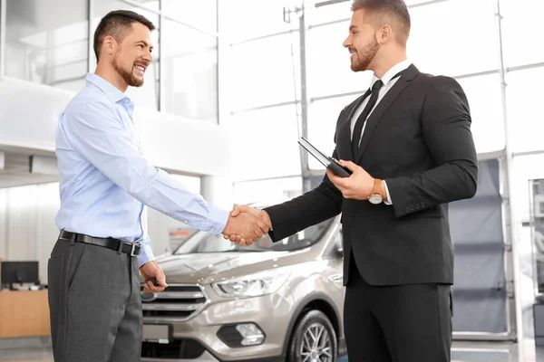 Man buying new car in salon — Stock Photo, Image