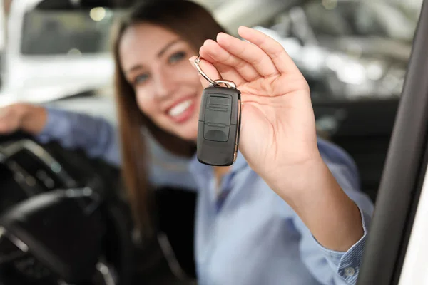 Happy female buyer with key sitting in new car, closeup — Stock Photo, Image