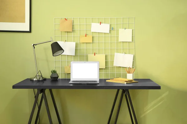 Local de trabalho confortável com laptop moderno e moodboard perto da parede de cor — Fotografia de Stock