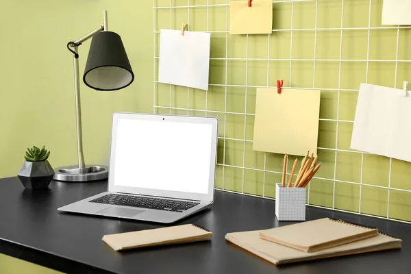 Bekväm arbetsplats med modern bärbar dator och moodboard nära färgvägg — Stockfoto