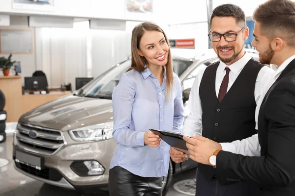 Pareja comprando coche nuevo en el salón —  Fotos de Stock