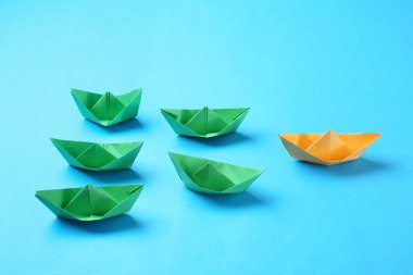 Renkli yeşil olanlar arasında turuncu origami teknesi. Eşsizlik kavramı