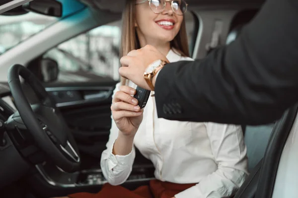 Venditore dando la chiave dalla nuova auto alla giovane donna — Foto Stock