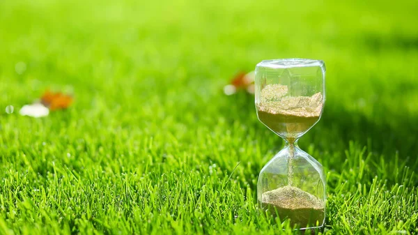 Hourglass on green grass outdoors — Φωτογραφία Αρχείου