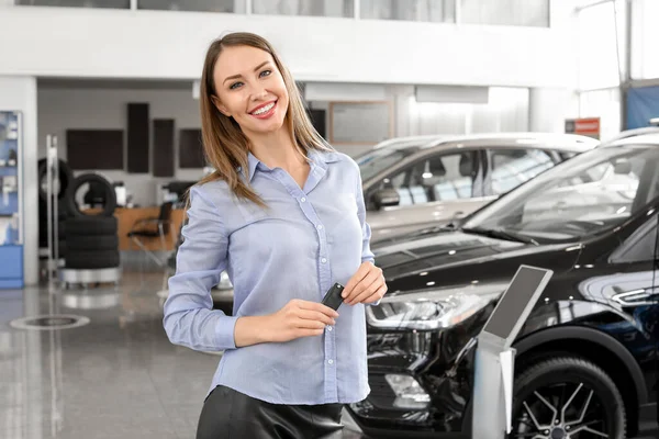 Heureux acheteur féminin près de nouvelle voiture dans le salon — Photo