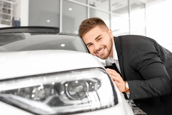 Heureux acheteur masculin près de nouvelle voiture dans le salon — Photo