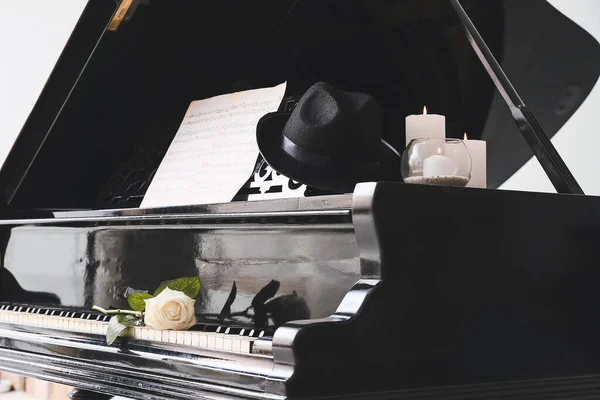 Stylový klavír se svíčkami a růžovým květem na pokoji — Stock fotografie