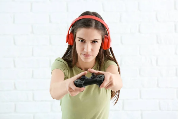 Menina adolescente com almofada de jogo no fundo de tijolo branco — Fotografia de Stock
