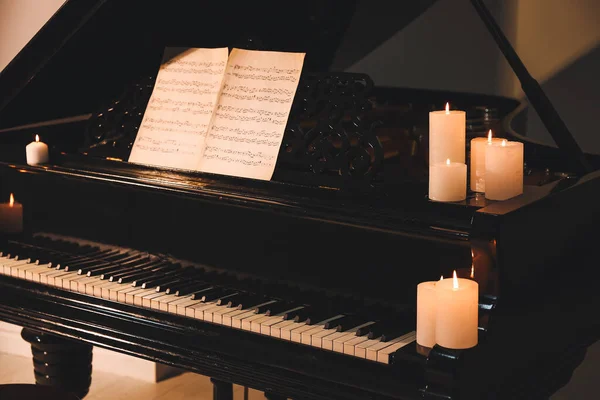 Akşamları yanan mumlarla süslü bir kuyruklu piyano. — Stok fotoğraf