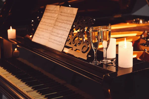 Piano à queue élégant avec bougies allumées et verres de champagne en soirée — Photo