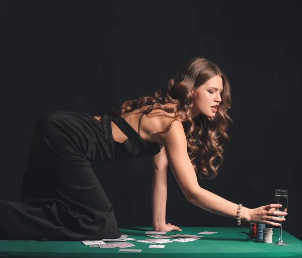 Female player with glass of champagne on table in casino — Stock Photo, Image